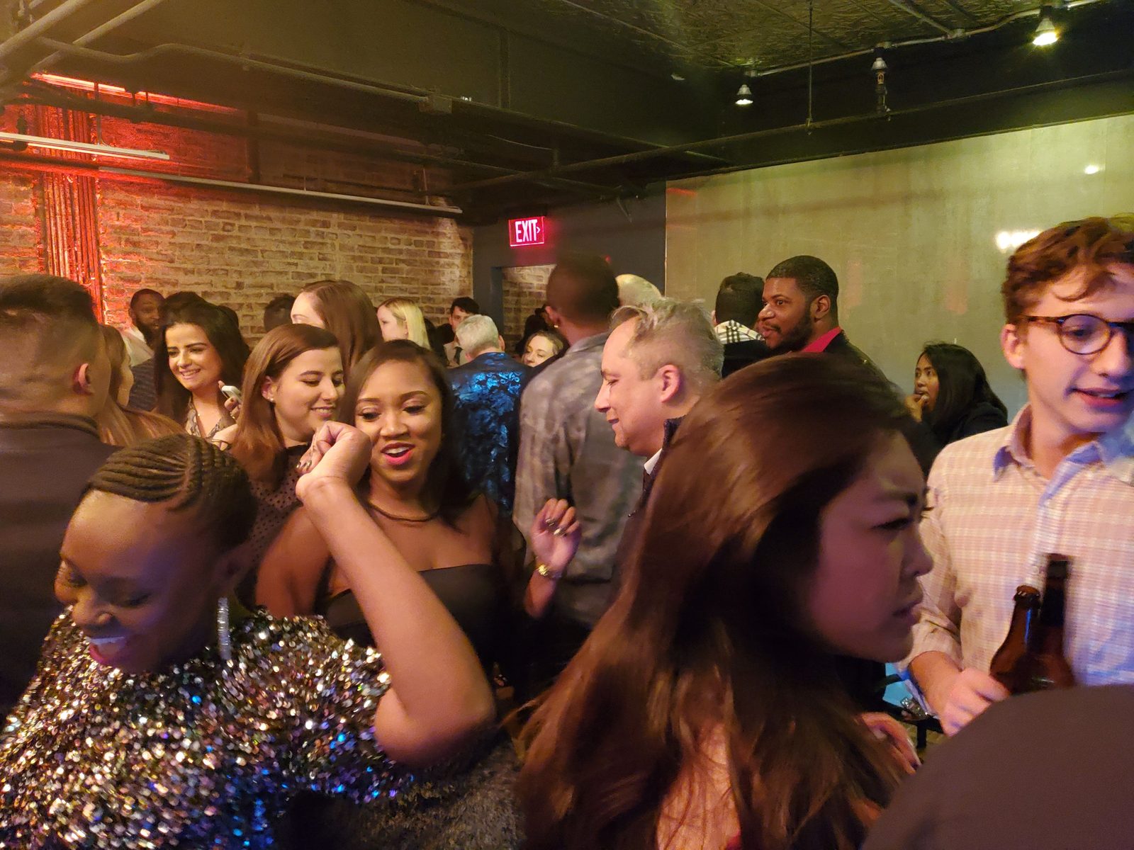 Coworkers celebrating under warm red uplighting at a corporate holiday party in the DMV