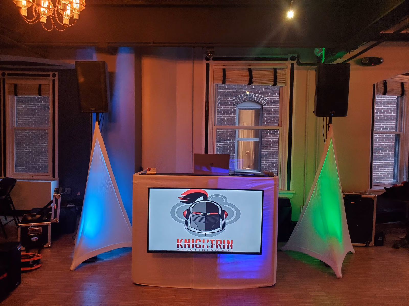 Knightrin DJ booth with blue and green uplighting set up for a corporate holiday party in the DMV